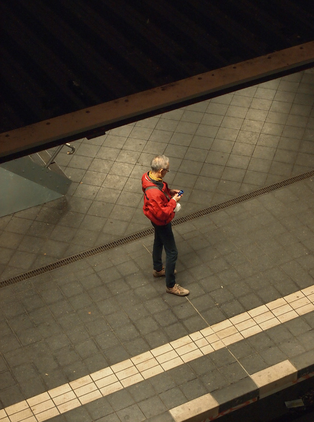 A man waiting for the train at a subway station.
