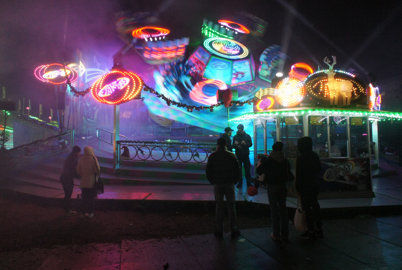 A colorful ride takes off at the funfair at night.