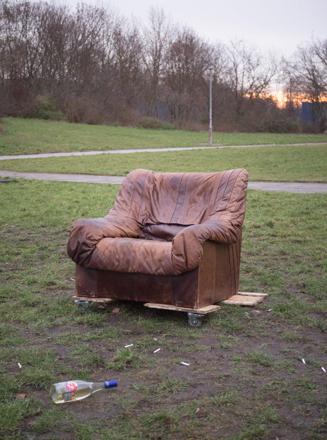 An old leather armchair, abandoned in a park.